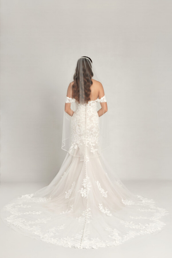 Ethereal wedding dress with off the shoulder sleeves and a sweetheart neckline, the lace floral appliques move throughout the dress and train.