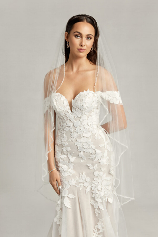 Ethereal wedding dress with off the shoulder sleeves and a sweetheart neckline, the lace floral appliques move throughout the dress and train.