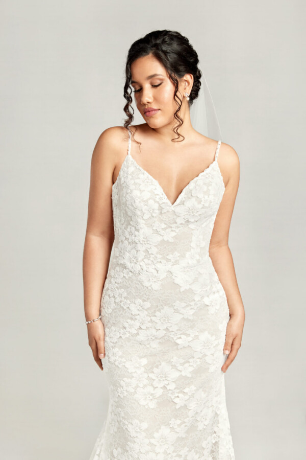 Traditional boho lace wedding dress with spaghetti straps and floral lace overlay.