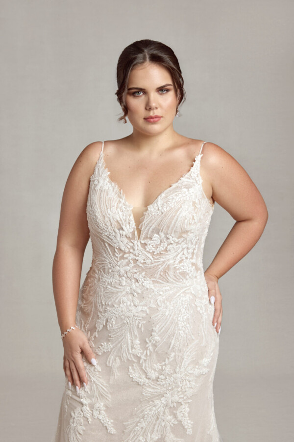 Bride to be wearing a boho wedding dress with spaghetti straps and floral lace appliques throughout.