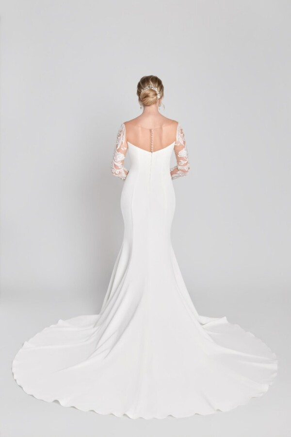 Stunning bride to be wearing a simple, sheath wedding dress with lace, long sleeves and buttons down the back.