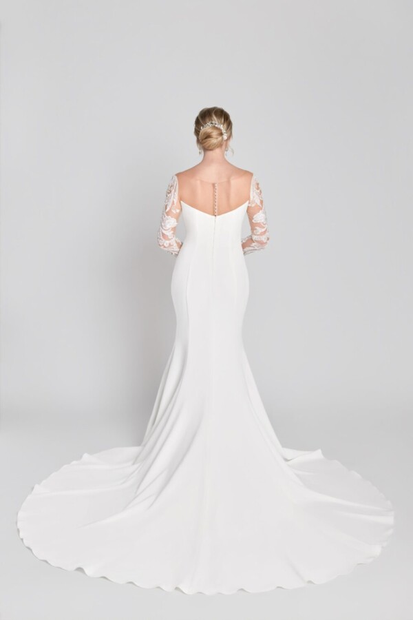 Stunning bride to be wearing a simple, sheath wedding dress with lace, long sleeves and buttons down the back.
