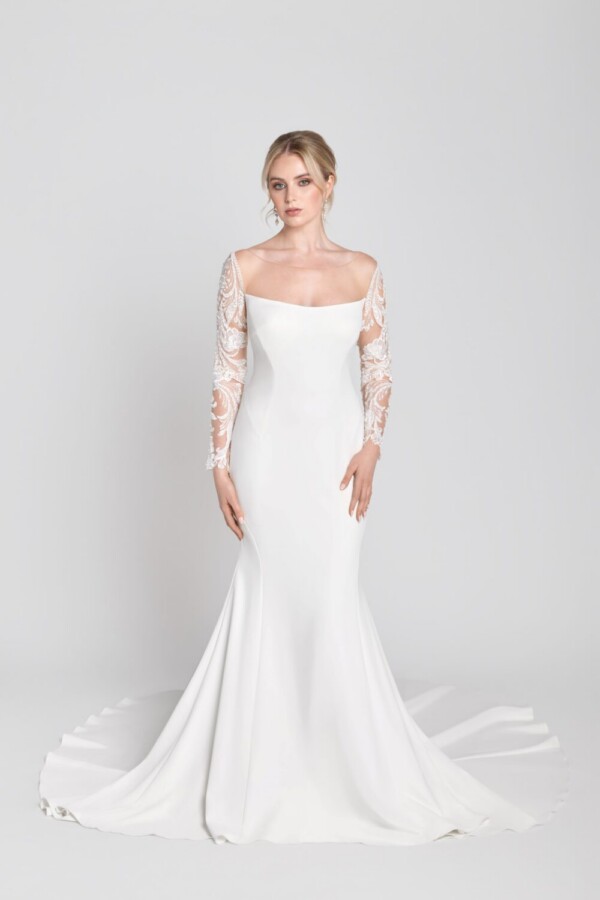 Stunning bride to be wearing a simple, sheath wedding dress with lace, long sleeves.