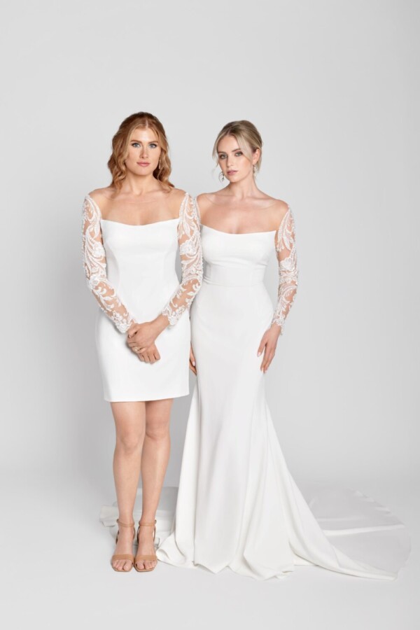 Stunning brides standing together wearing the same simple, sheath wedding dress with lace, long sleeves, one dress short and one long.