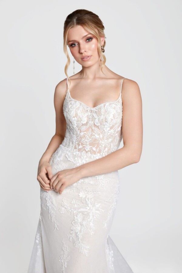 Captivating young bride to be wearing her boho lace wedding dress with spaghetti straps and floral details on the bodice.