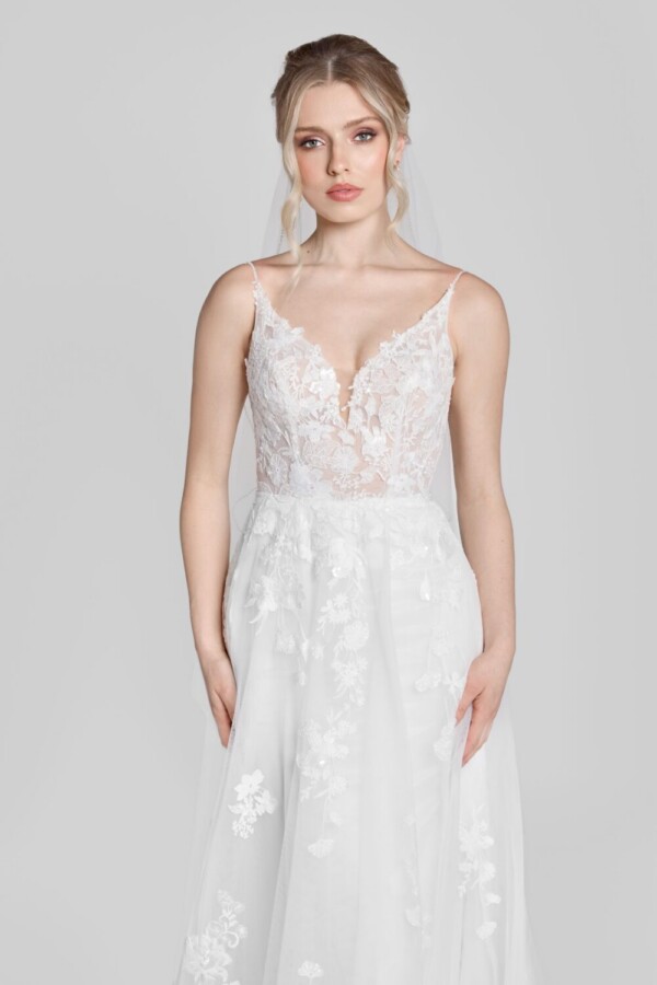 Show stopping wedding dress with spaghetti straps and floral lace details on the bodice, flowing onto the skirt.