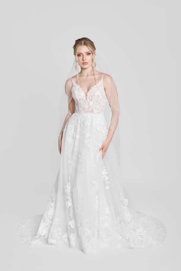 Show stopping wedding dress with spaghetti straps and floral lace details on the bodice, flowing onto the skirt.