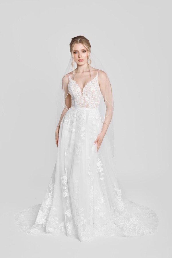 Show stopping wedding dress with spaghetti straps and floral lace details on the bodice, flowing onto the skirt.