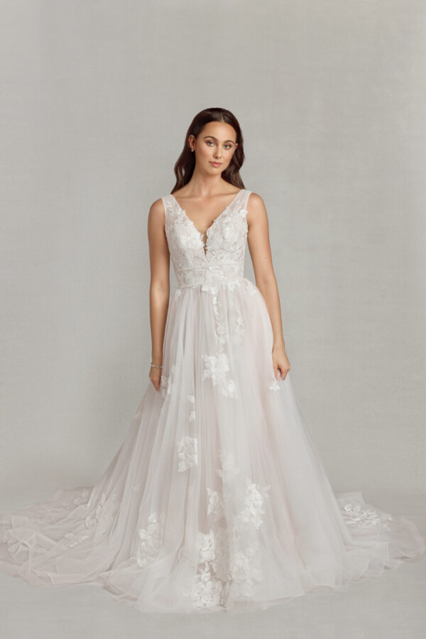 Whimsical bride to be wearing a bohemian wedding dress with floral lace on the bodice and a multilayered, tulle skirt.