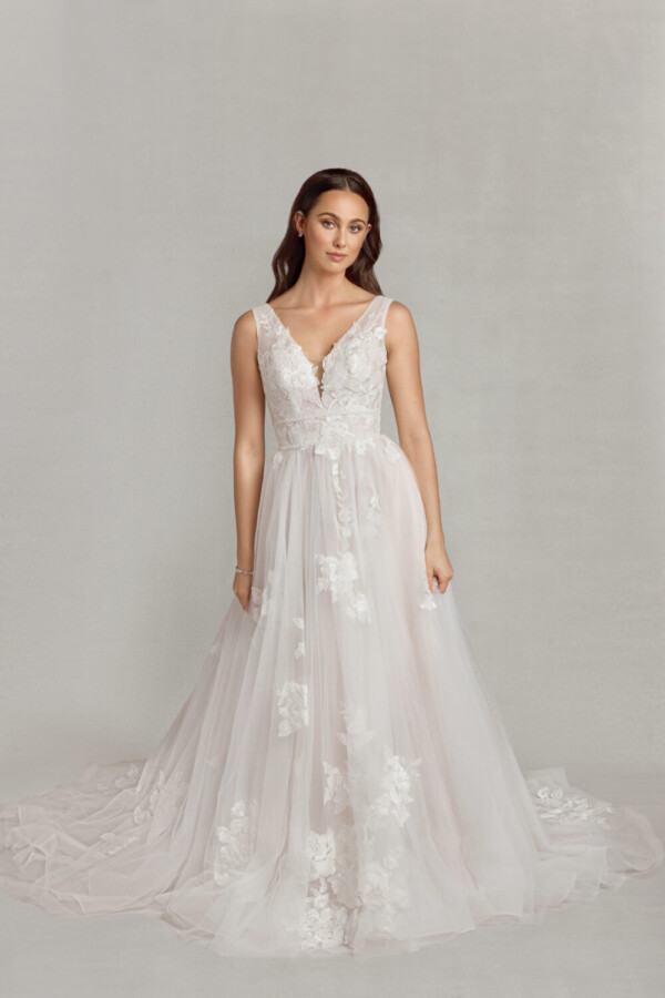 Whimsical bride to be wearing a bohemian wedding dress with floral lace on the bodice and a multilayered, tulle skirt.