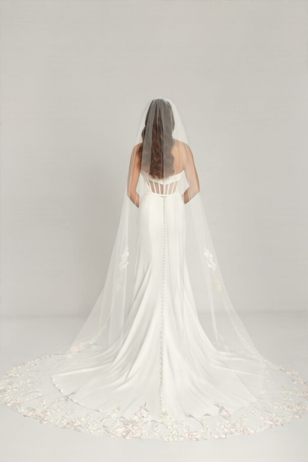 Gorgeous bride to be wearing a fit and flare wedding dress with keyhole cutouts on the back and buttons down the spine.