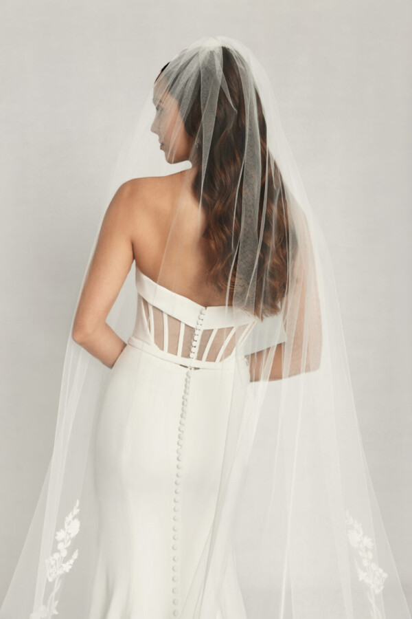 Gorgeous bride to be wearing a fit and flare wedding dress with keyhole cutouts on the back and buttons down the spine.