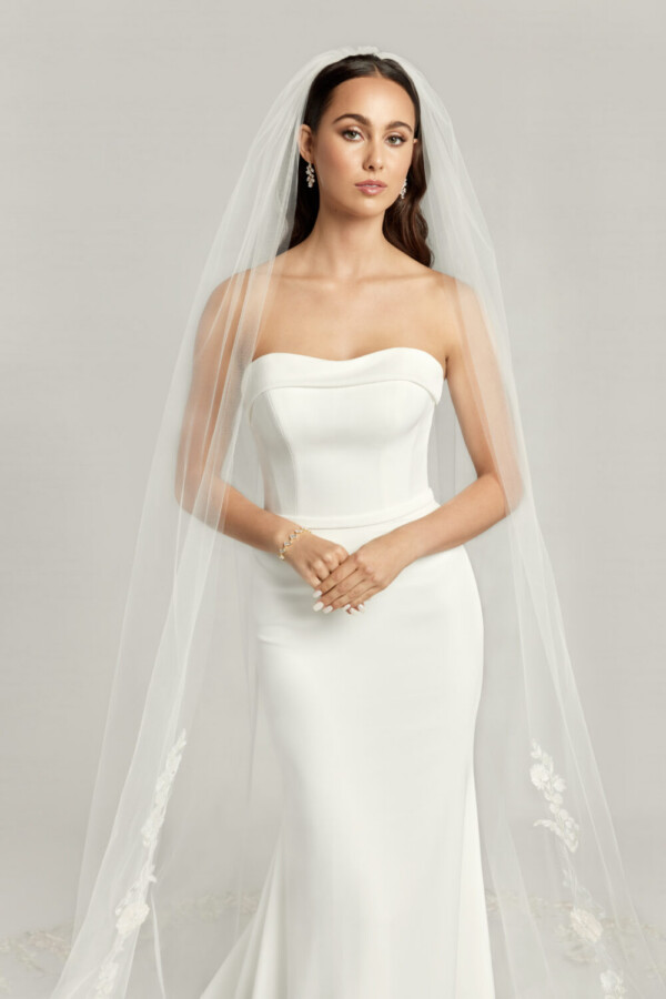 Gorgeous bride to be wearing a fit and flare wedding dress with sweetheart neckline and simple, cathedral length veil.