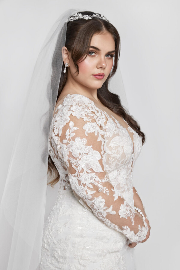 Gorgeous bride to be wearing a long sleeve plus size wedding dress with floral lace detailing throughout.