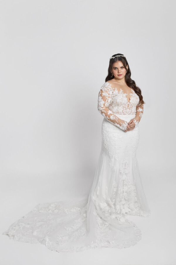 Gorgeous bride to be wearing a long sleeve plus size wedding dress with floral lace detailing throughout.