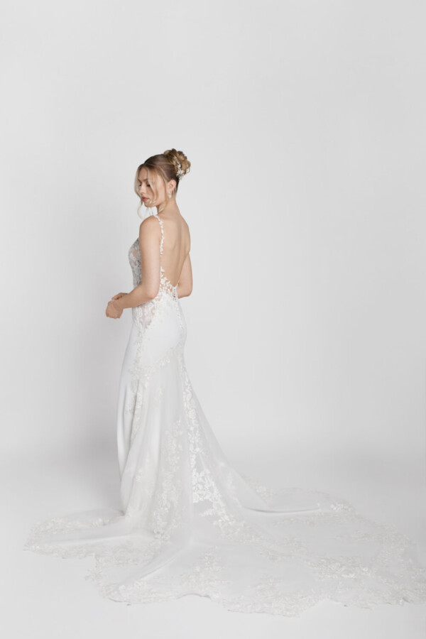 Backless wedding dress made of floral lace with spaghetti straps and a star train spread around the bride to be.