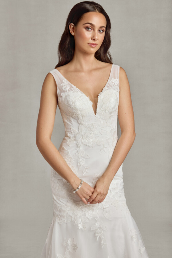 Young bride to be wearing a sit and flare wedding dress with floral lace details on the bodice flowing onto the multilayered, tulle skirt.