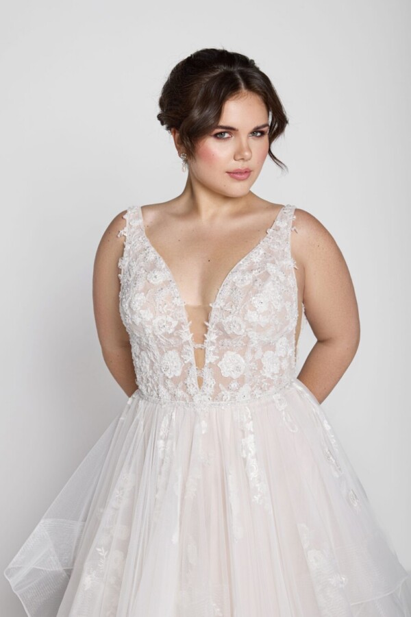 Charming bride to be wearing a square neckline wedding dress with floral lace on the bodice and decals throughout the tulle skirt.