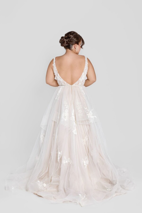 Charming bride to be wearing a square neckline wedding dress with floral lace on the bodice and decals throughout the tulle skirt.