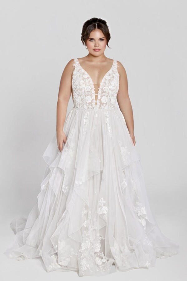 Charming bride to be wearing a square neckline wedding dress with floral lace on the bodice and decals throughout the tulle skirt.