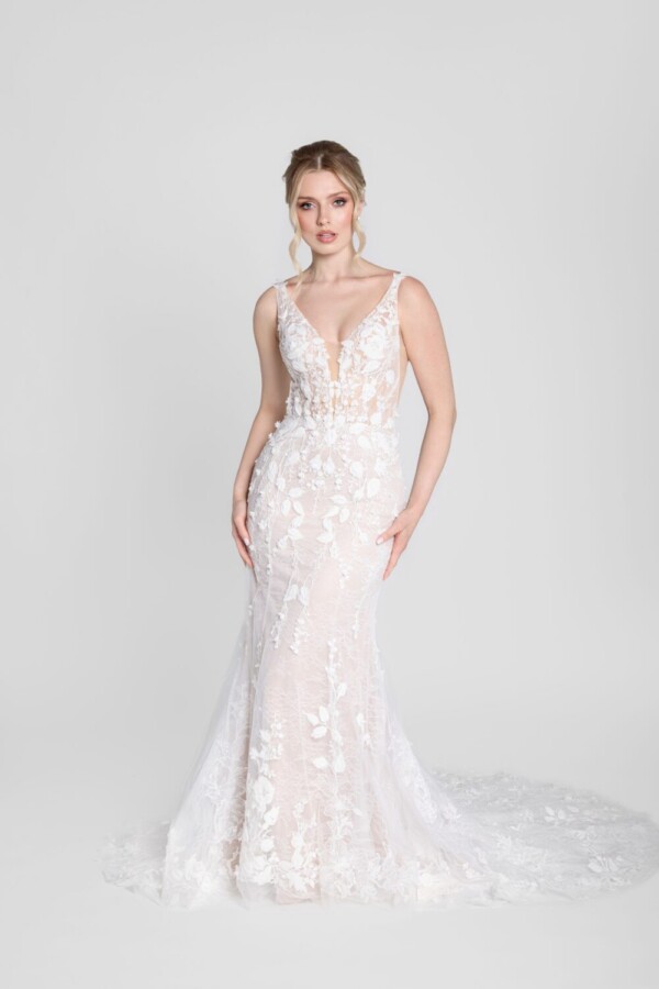 Bride wearing a fit and flare style wedding dress with deep v cut neckline and floral details flowing from the bodice onto the skirt with a simple, floral train.