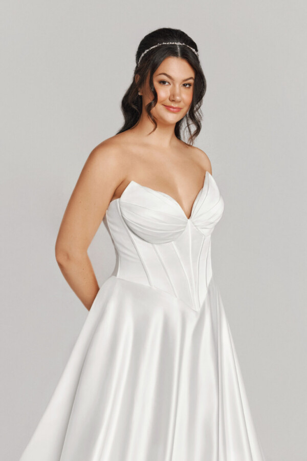 A bride in a white fitted strapless dress.
