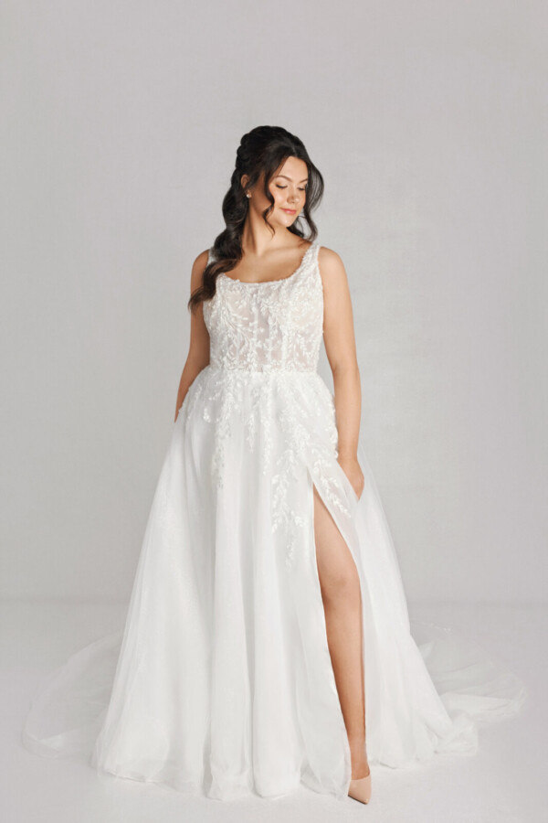 A bride in a white fitted lace floral dress with leg slit.