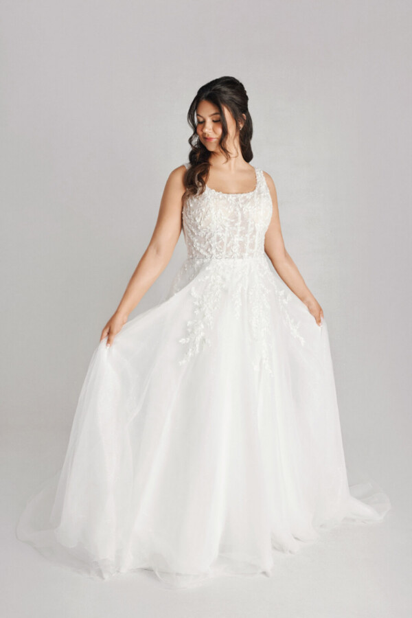 A bride in a white fitted lace floral dress.