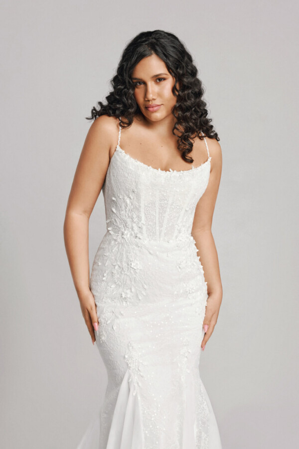 A bride in a white fitted slim strapped dress.