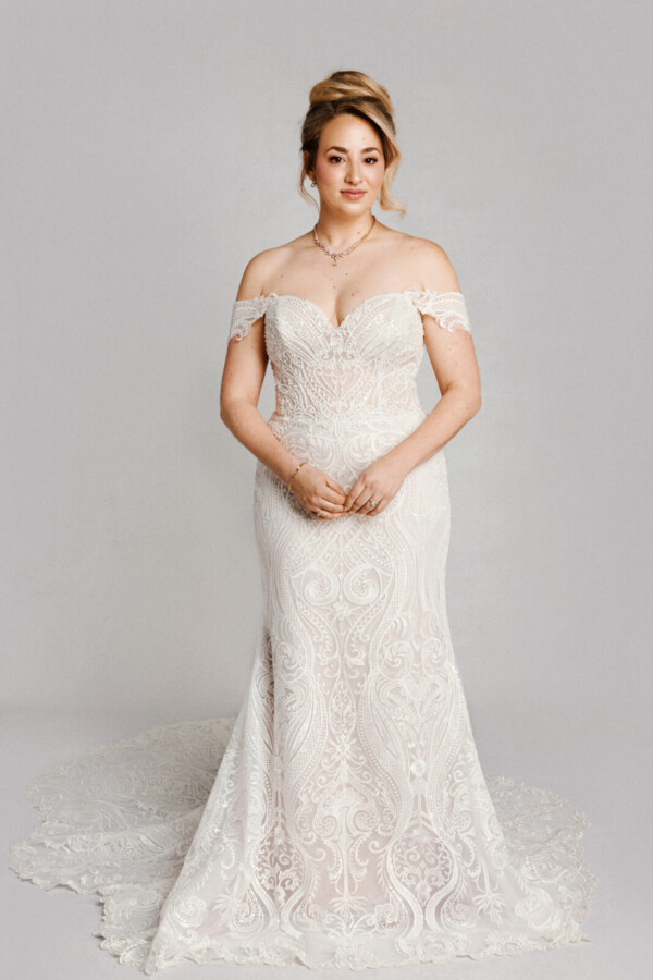 A bride in a white flowy lace floral deep v cut dress.