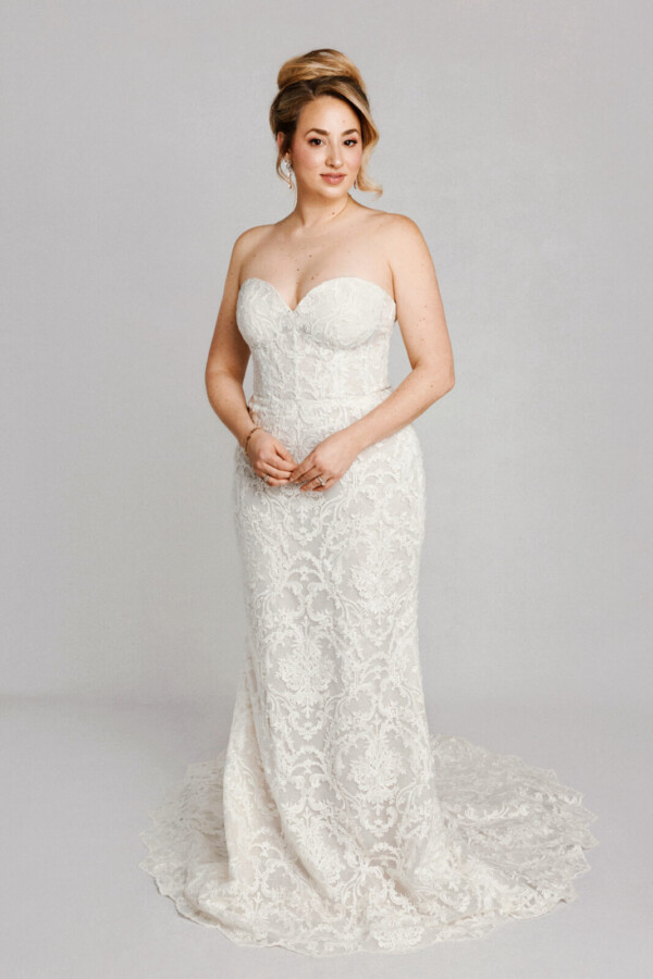 A bride in a white fitted strapless dress.