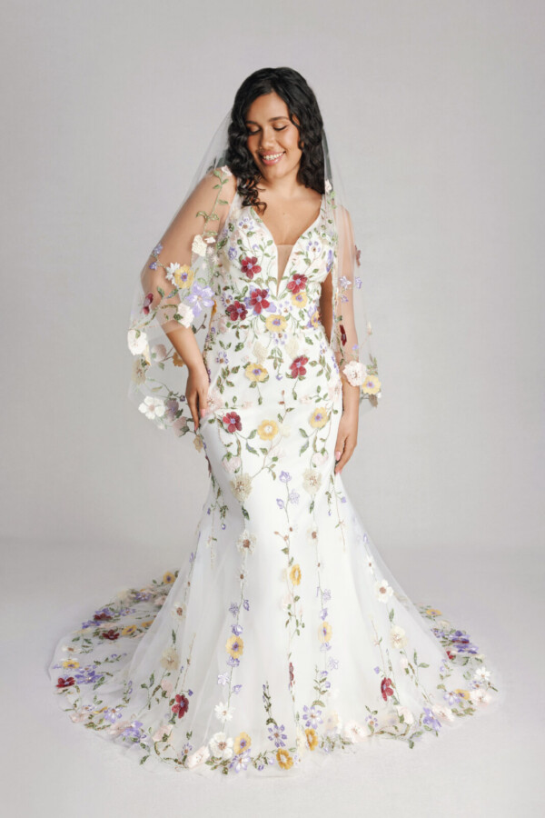 A bride in a sheer floral fitted slim strap dress with bridal veil.