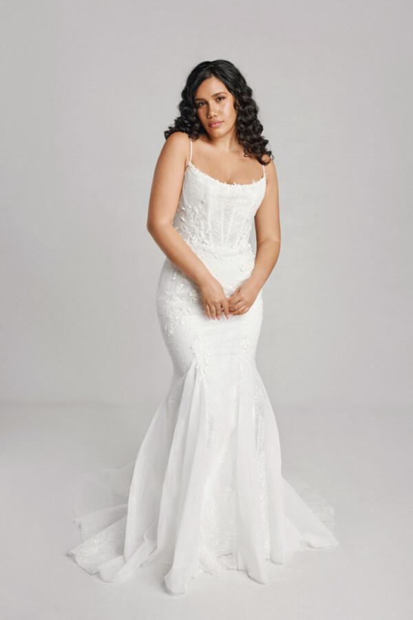 A bride in a white fitted slim strapped dress.