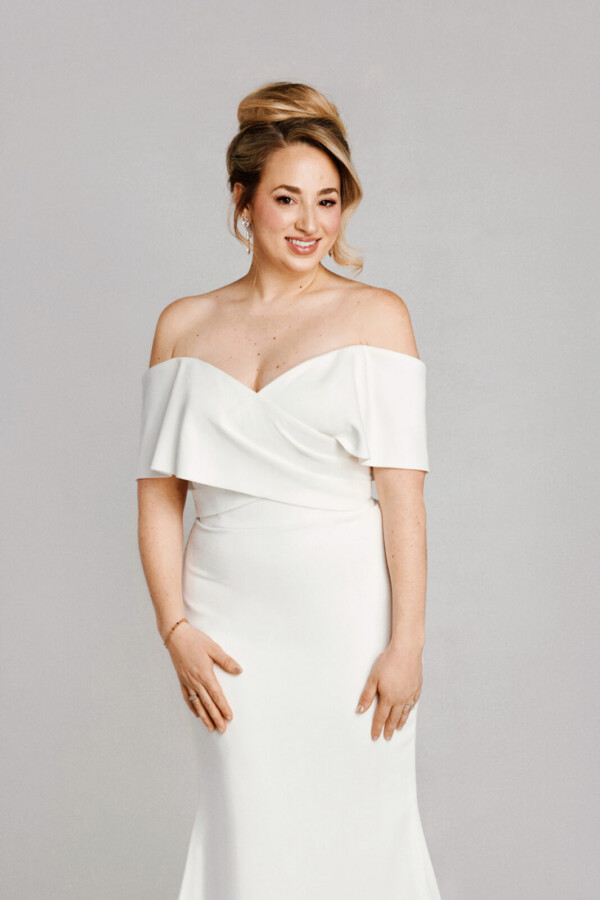 A bride in a white flowy off the shoulder dress.