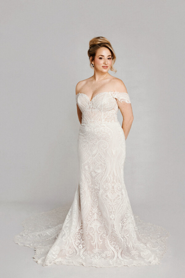 A bride in a white flowy lace floral deep v cut dress.