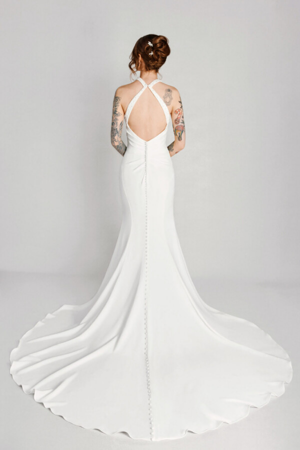 A bride in a white flowy open back dress.