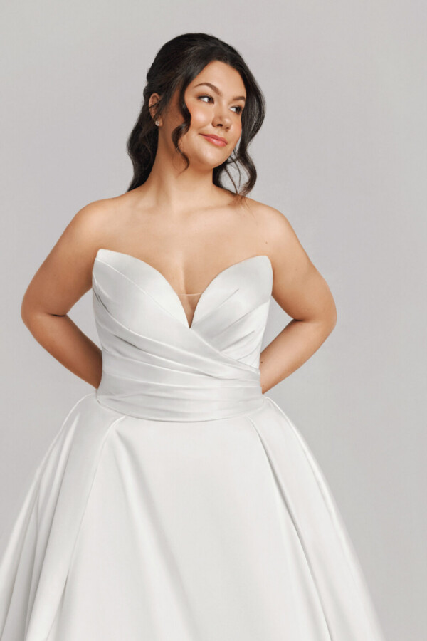 A bride in a white fitted strapless dress.