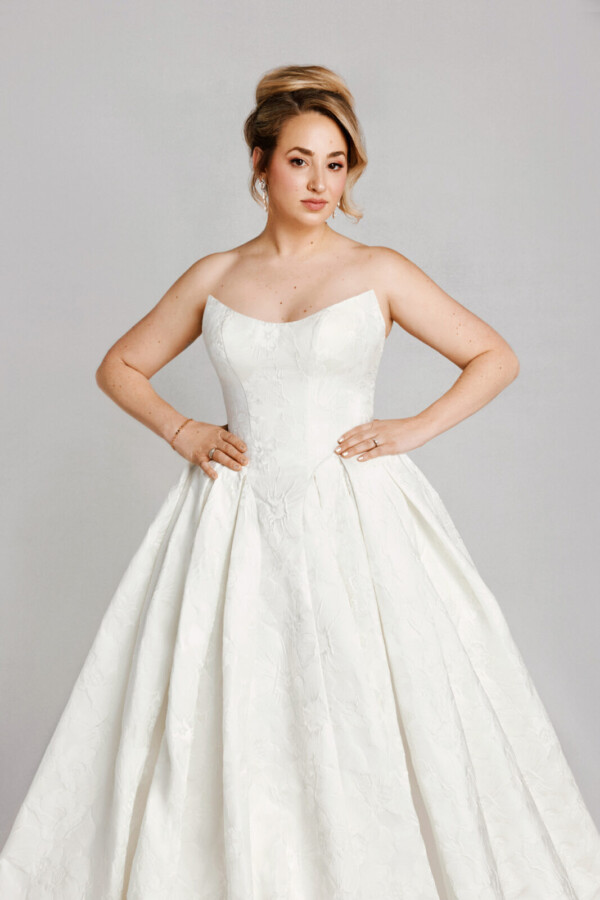 A bride in a white fitted strapless dress.