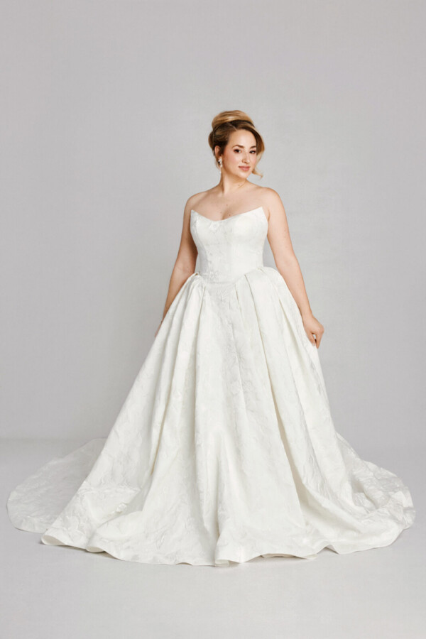 A bride in a white fitted strapless dress.