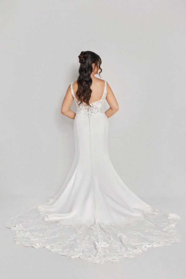 A bride in a white flowy lace floral open back dress.