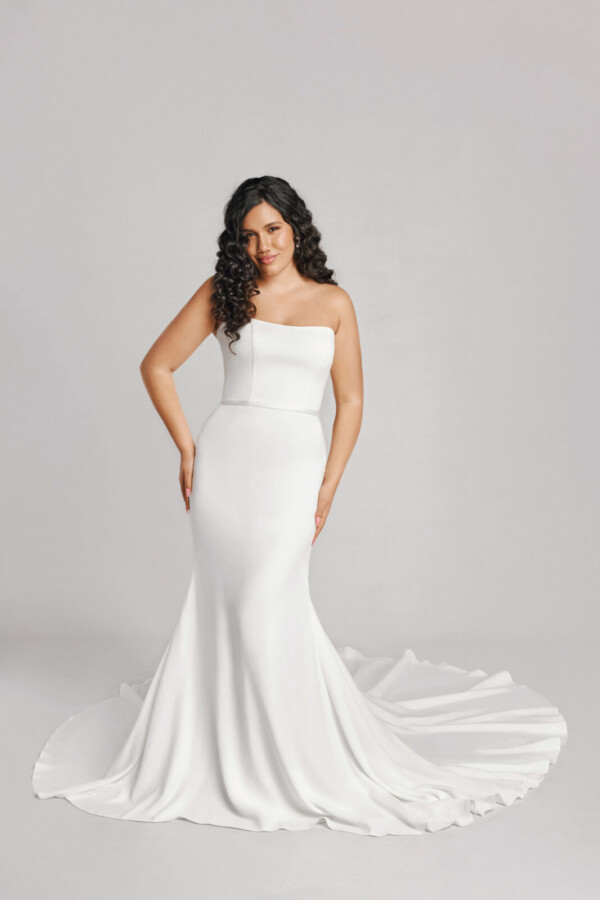 A bride in a white fitted slim strapless dress.