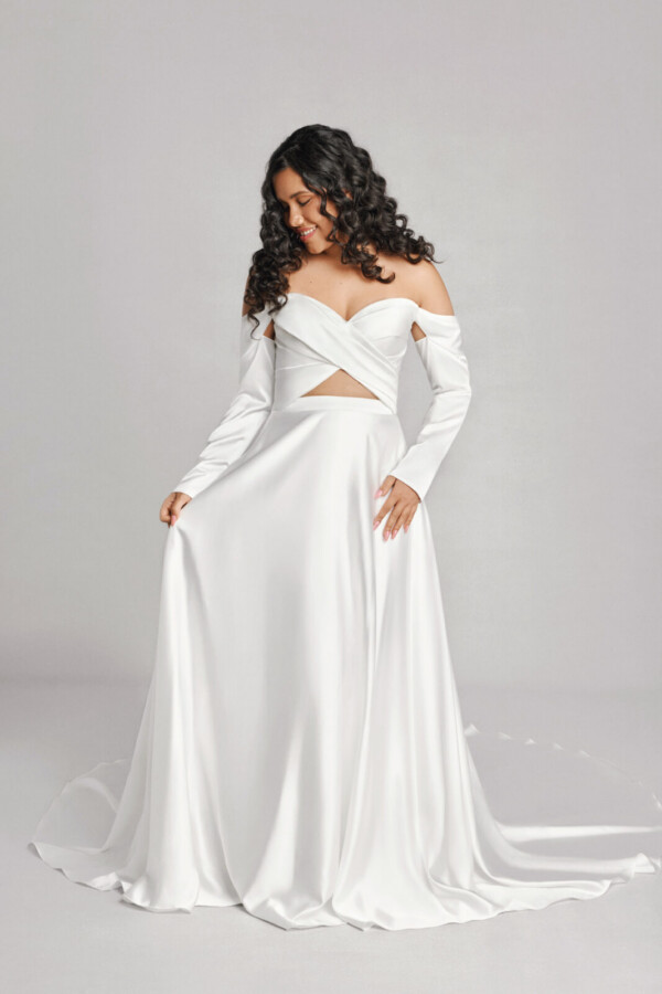 A bride in a white fitted off the shoulder flowy dress.