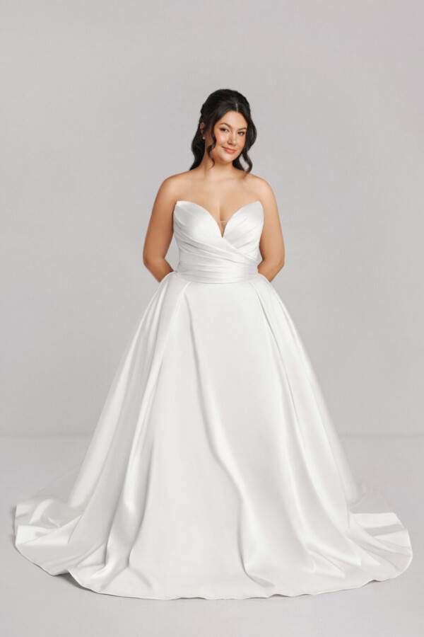 A bride in a white fitted strapless dress.