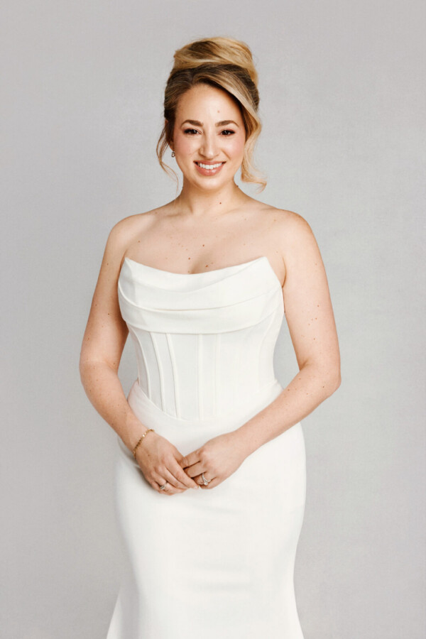 A bride in a white fitted strapless dress.