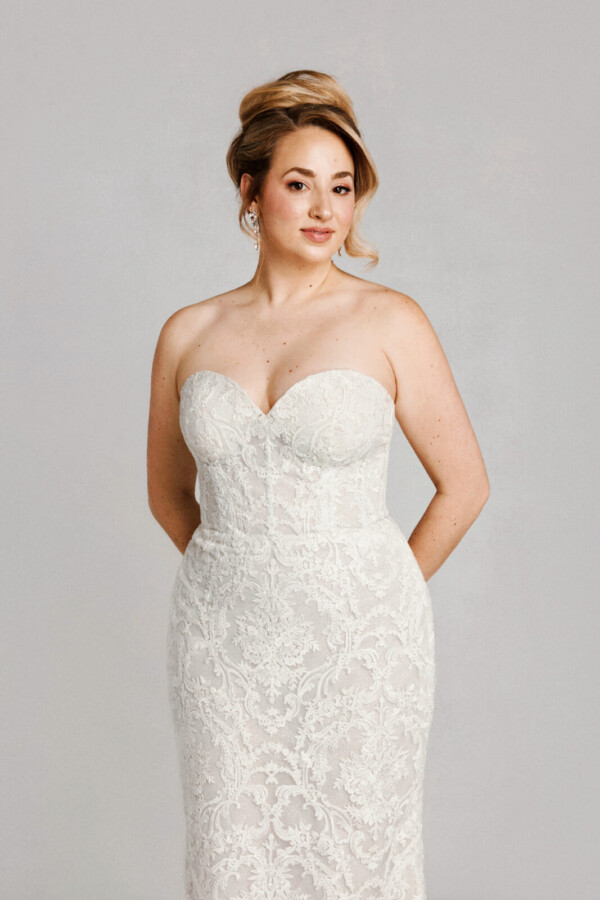 A bride in a white fitted strapless dress.