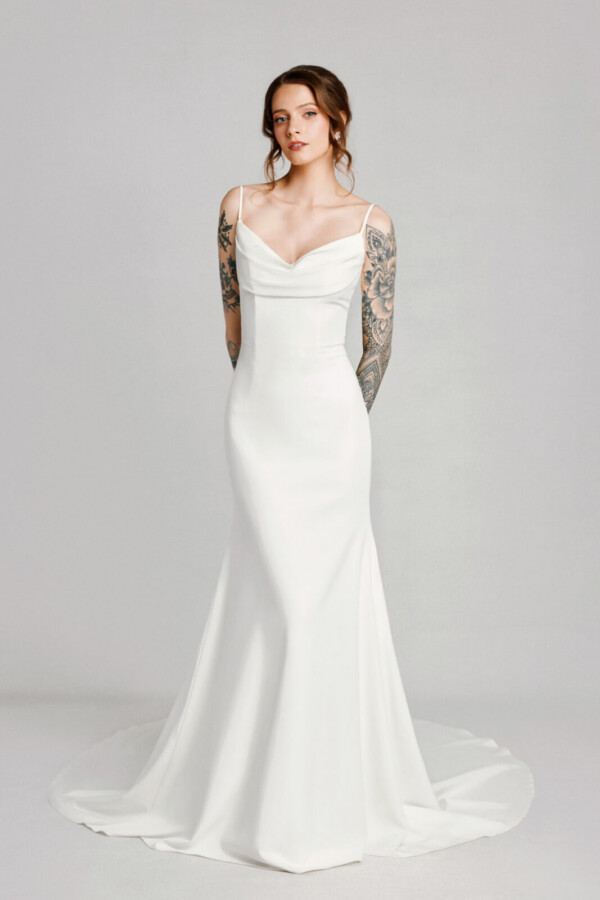 A bride with tattoos in a white fitted slim strapped dress.