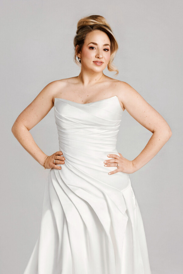 A bride in a white fitted slim strapless dress.