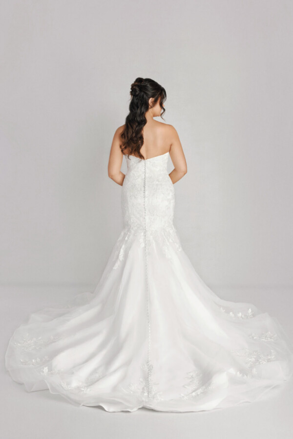 A bride in a white flowy open back dress.