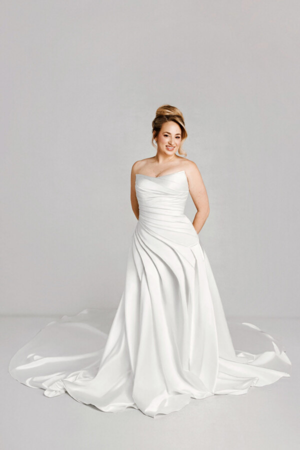A bride in a white fitted slim strapless dress.